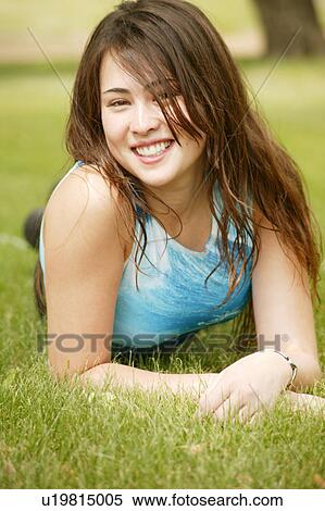 Teenager lays on grass View Large Photo Image Stock Photography - Teenager lays on grass. Fotosearch
