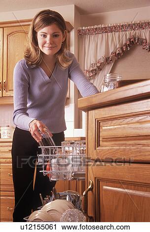 Teenager loading dishes into dishwasher View Large Photo Image Stock Image - Teenager loading dishes into dishwasher. Fotosearch