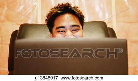 Stock Photo - Teenager sits in a room. Fotosearch