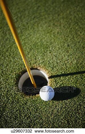 Stock Image - The ball next to the hole. Fotosearch