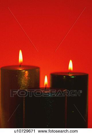 Stock Image - Three lit candles. Fotosearch