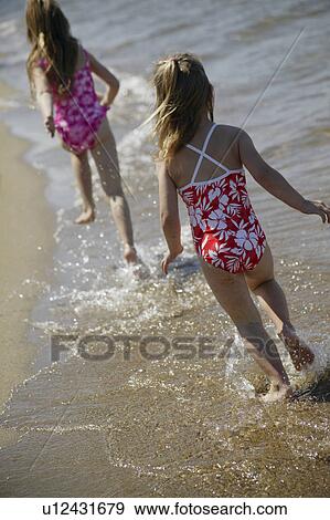 Stock Photo - Two children running along the beach. Fotosearch