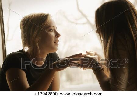 Stock Image - Two girls having coffee. Fotosearch