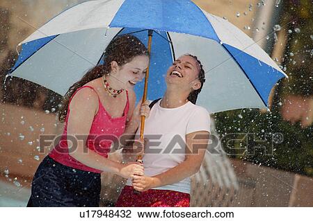 Stock Image - Two girls under an umbrella. Fotosearch