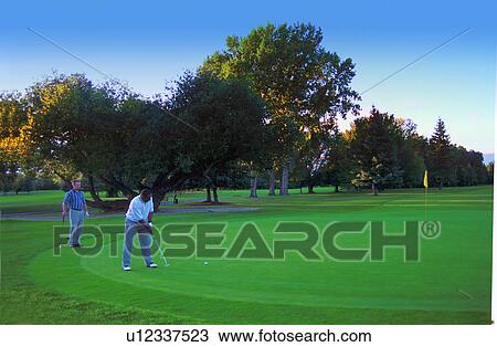 Stock Image - Two golfers on the green. Fotosearch