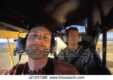 Two men flying in an airplane View Large Photo Image Stock Photograph - Two men flying in an airplane. Fotosearch