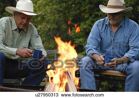 Two men sit by the fire View Large Photo Image Stock Image - Two men sit by the fire. Fotosearch