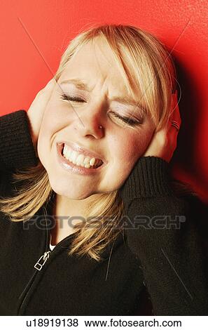 Stock Photo - Woman holds hands over her ears. Fotosearch