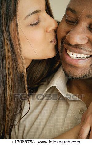 Stock Photo - Woman kisses man. Fotosearch