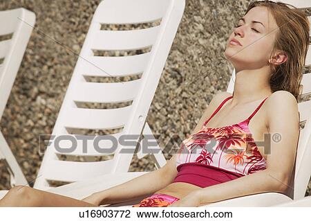 Stock Image - Woman lays in the sun. Fotosearch