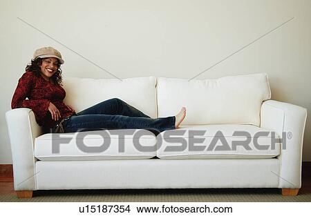 Woman relaxes on sofa View Large Photo Image Picture - Woman relaxes on sofa. Fotosearch