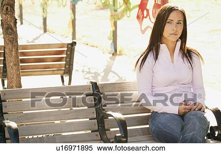 Stock Photography - Woman sits on a bench. Fotosearch