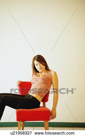Woman sits on chair View Large Photo Image Stock Photo - Woman sits on chair. Fotosearch