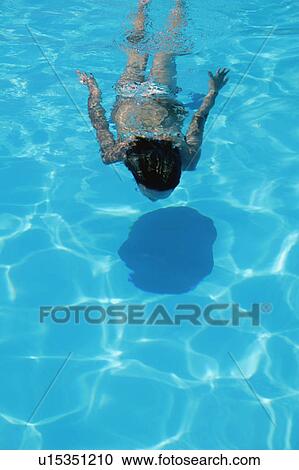 Stock Image - Woman swims underwater. Fotosearch