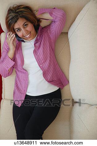 Woman talks on cell phone whilst relaxing View Large Photo Image Stock Image - Woman talks on cell phone whilst relaxing. Fotosearch