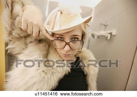 Stock Photograph - Woman tries on a fur coat. Fotosearch