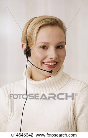Stock Image - Woman wearing telephone headset. Fotosearch