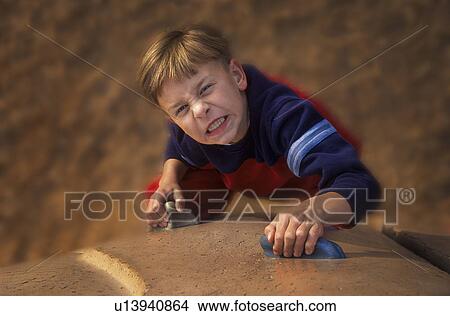 Picture - Young boy ascending climbing wall. Fotosearch