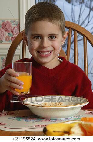 Young boy with food at breakfast table View Large Photo Image Picture - Young boy with food at breakfast table. Fotosearch