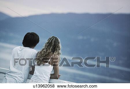 Young couple enjoying the view View Large Photo Image Stock Photo - Young couple enjoying the view. Fotosearch