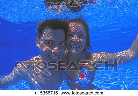 Young couple in swimming pool View Large Photo Image Stock Photograph - Young couple in swimming pool. Fotosearch