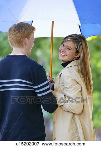 Young couple with an umbrella View Large Photo Image Stock Photo - Young couple with an umbrella. Fotosearch