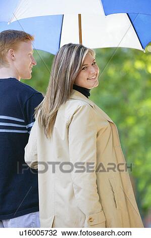 Stock Image - Young couple with umbrella. Fotosearch