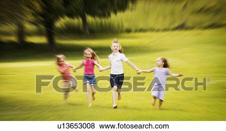 Young girls running in the park View Large Photo Image Stock Photo - Young girls running in the park. Fotosearch