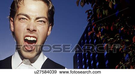 Young man in casual suit shouting building in background View Large Photo Image Stock Photo - Young man in casual suit shouting building in background. Fotosearch