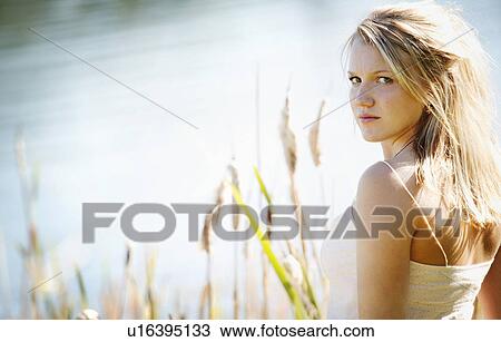 Stock Image - Young woman glancing over her shoulder. Fotosearch