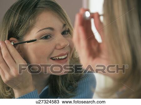 Young woman putting on mascara View Large Photo Image Stock Image - Young woman putting on mascara. Fotosearch