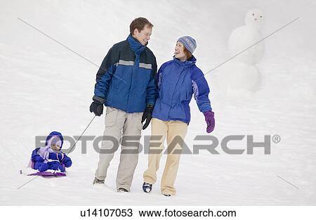 Family enjoying a walk in the snow View Large Photo Image Stock Image - Family enjoying a walk in the snow. Fotosearch