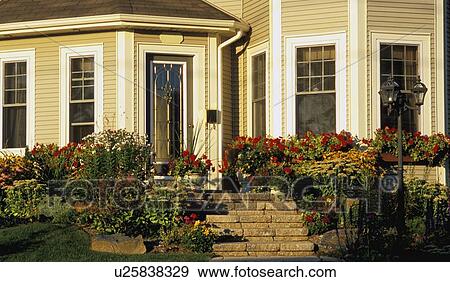 Stock Photo - The front entrance of a house with a flower garden. Fotosearch