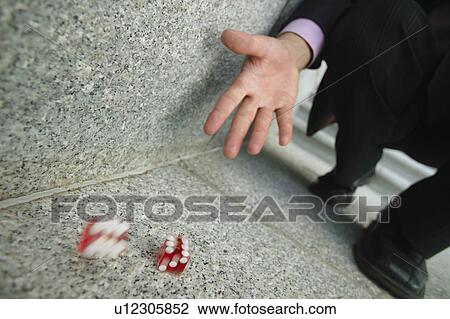 Stock Image - Businessman throws dice. Fotosearch