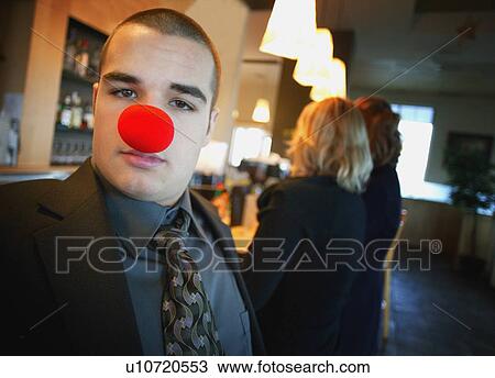 Stock Image - Businessman wearing red nose. Fotosearch