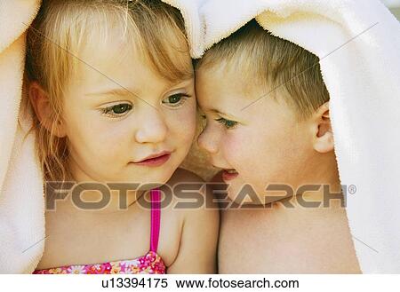 Stock Photography - Two kids snuggle under a towel. Fotosearch