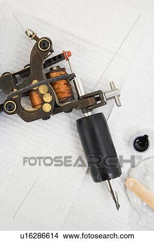 Picture - Close up shot of tattoo gun and black ink.. Fotosearch