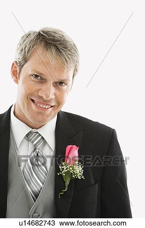 Stock Image - Portrait of Caucasian male in tuxedo with boutonniere.. Fotosearch