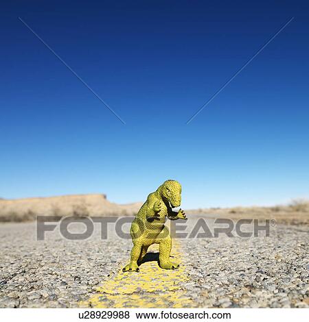 Stock Photo - Toy dinosaur in middle of road.. Fotosearch