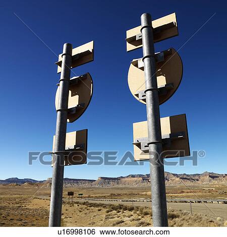 Stock Photograph - Two road signs on a psot with guardrail and mountains in background.. Fotosearch