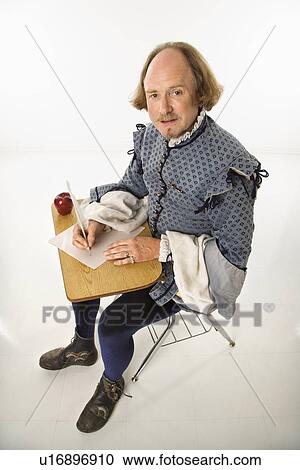 William Shakespeare in period clothing sitting in school desk writing with quill pen. View Large Photo Image Stock Image - William Shakespeare in period clothing sitting in school desk writing with quill pen.. Fotosearch