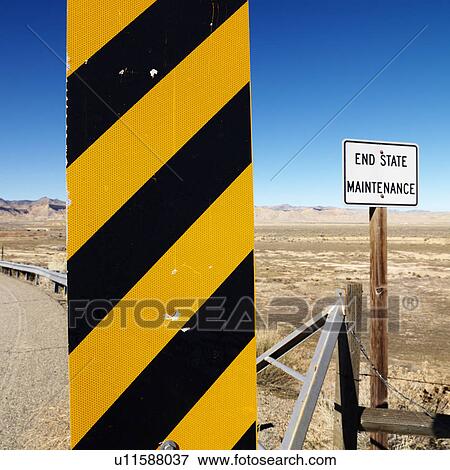 Stock Photo - Yellow and black caution sign with Utah landscape in background.. Fotosearch