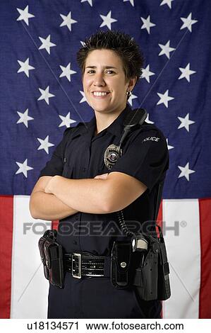 肖像画 の 中間の 大人 コーカサス人 婦人警官 地位 で 交差する 腕 で アメリカの旗 ように 背景 微笑 において Viewer ストックイメージ U Fotosearch