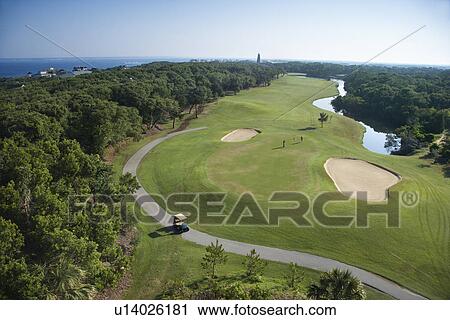 Stock Image - Aerial view of golf course in coastal residential community at Bald Head Island, North Carolina.. Fotosearch