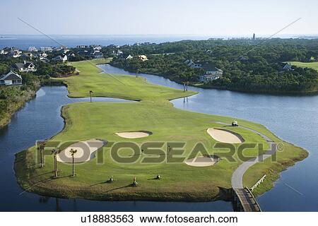 Stock Image - Aerial view of golf course in coastal residential community at Bald Head Island, North Carolina.. Fotosearch