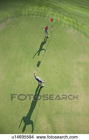 Picture - Aerial view of mid adult Caucasian man and woman being excited on golf course at Bald Head Island, North Carolina.. Fotosearch