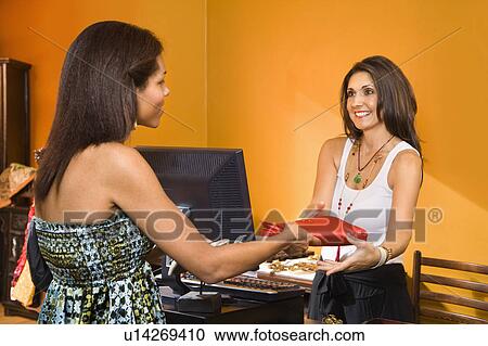 African American women handing item to sales clerk in boutique. View Large Photo Image Stock Image - African American women handing item to sales clerk in boutique.. Fotosearch