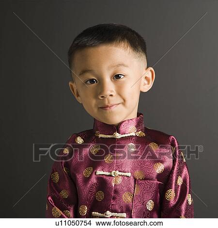 Asian boy in traditional attire standing against black background. View Large Photo Image Picture - Asian boy in traditional attire standing against black background.. Fotosearch