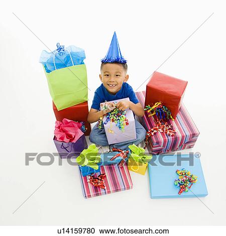 Asian boy wearing party hat sitting with pile of wrapped presents. View Large Photo Image Stock Image - Asian boy wearing party hat sitting with pile of wrapped presents.. Fotosearch