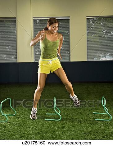 Asian female jumping over hurdles sideways inside. View Large Photo Image Stock Image - Asian female jumping over hurdles sideways inside.. Fotosearch